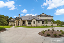 a large custom home with a circular driveway leading to the front door.