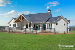 a large custom home with tall outdoor patio ceiling and pool.