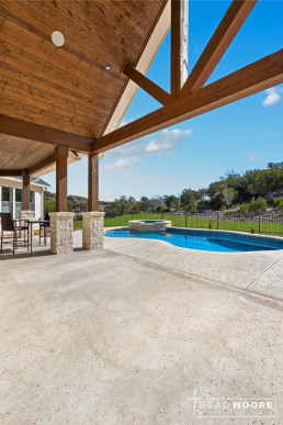a covered outdoor living area with high tongue & groove ceilings and a pool