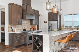 a custom home kitchen with a center island and bar stools