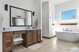 a large master bathroom with a tub, vanity sink and mirror