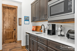 a prep kitchen or pantry with a sink, microwave and coffee maker.